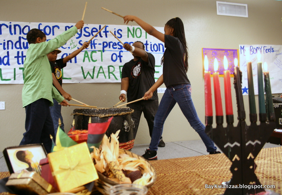 A group performs an African drum song during a Kwanzaa celebration